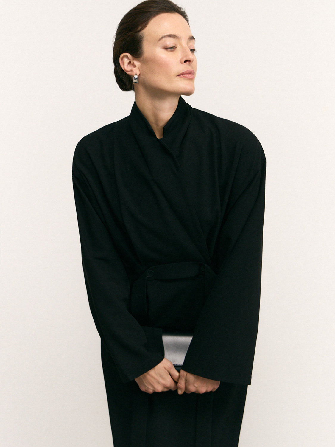 After retouch — model in black wrap blazer, subtle fabric and silhouette refinement