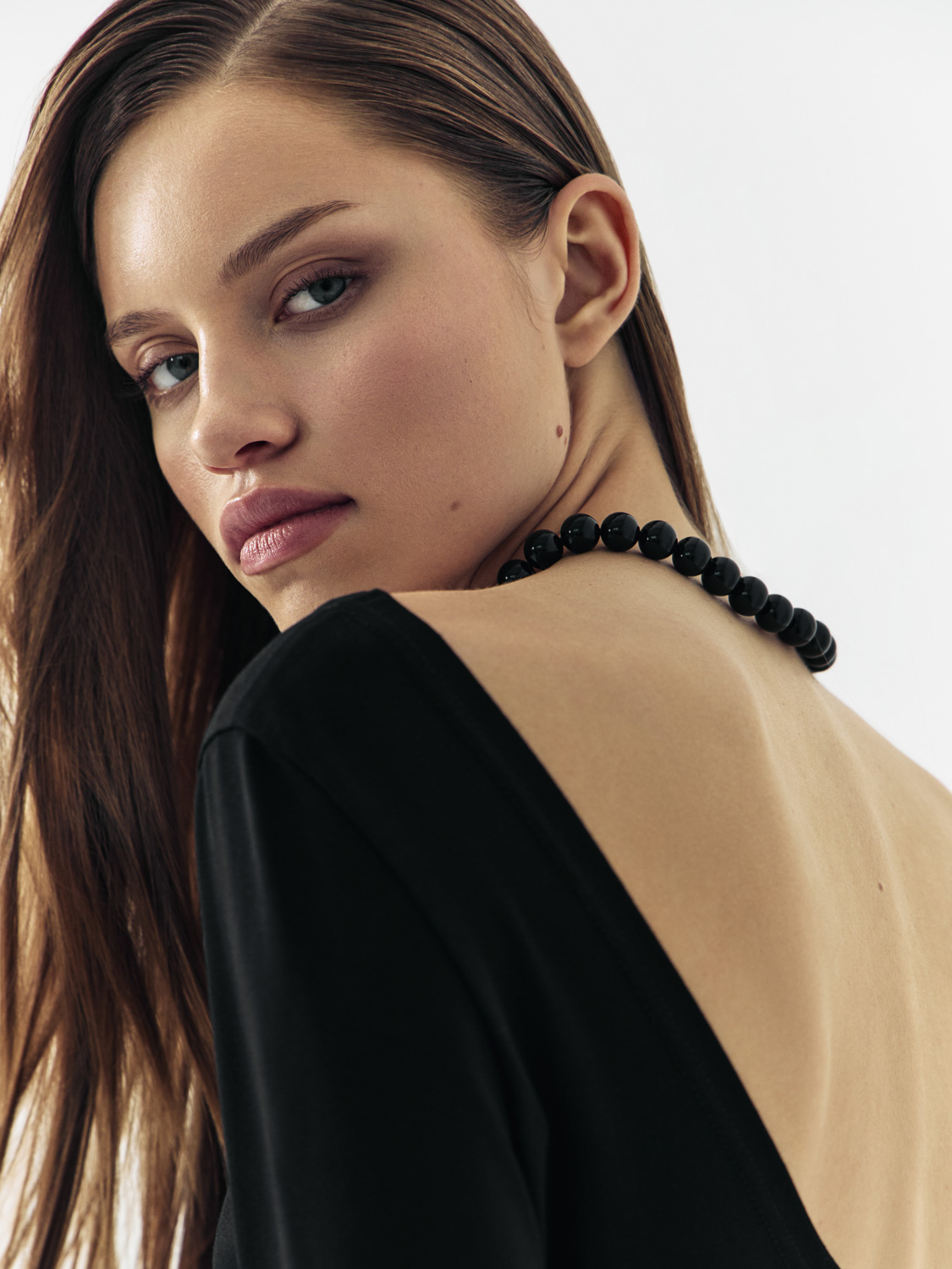 After retouch — same over-shoulder portrait, skin refined and luminous, natural features preserved