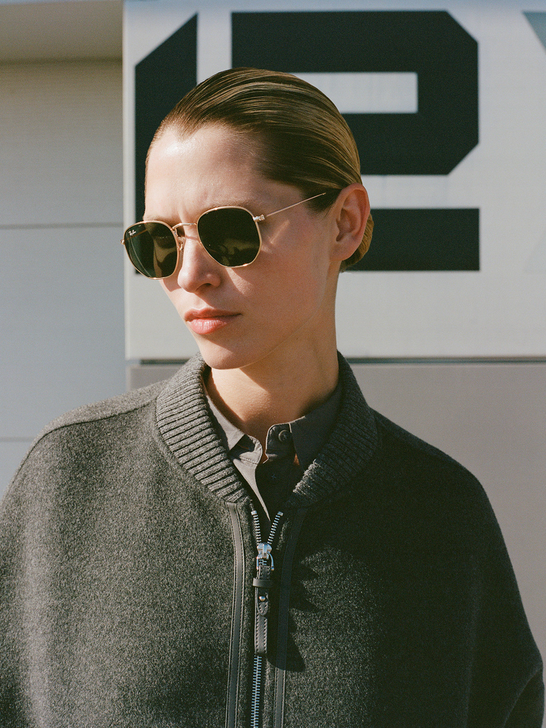 Campaign for 12storeez — model with slicked hair and Ray-Ban sunglasses in grey knit bomber