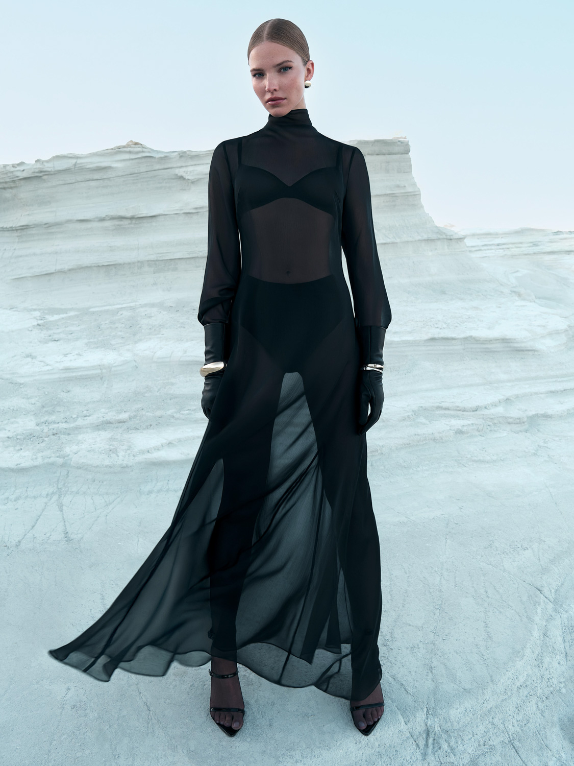 Campaign for LR — model in black sheer turtleneck maxi dress against white chalk cliffs