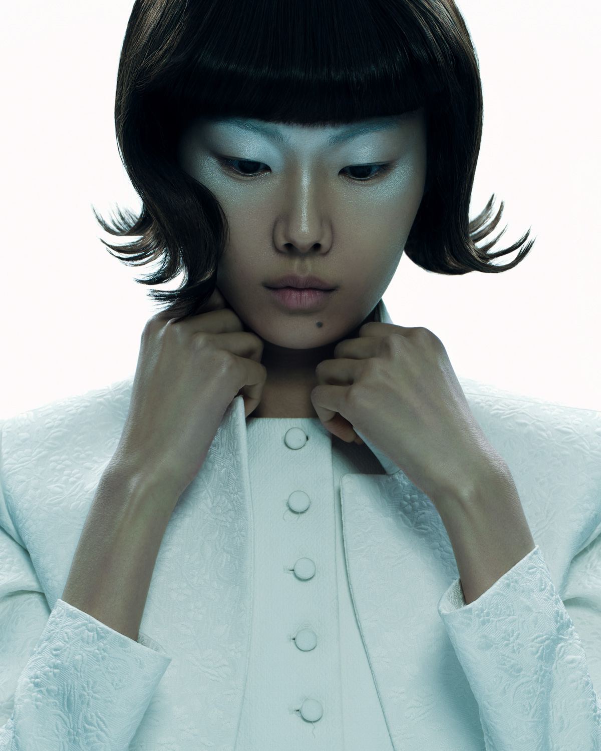 Vogue Philippines — close-up portrait in white embossed jacket, black bob haircut, hands at collar